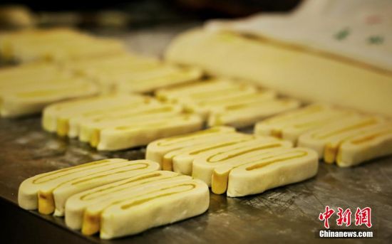 圖為面劑被涂上胡麻油，切成條狀用作月餅的花型制作。張文 攝