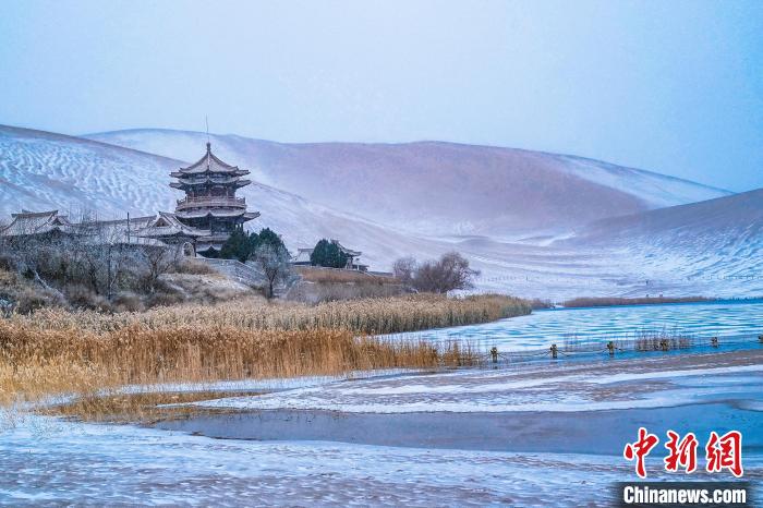 2021年11月28日，雪落鳴沙山月牙泉景區(qū)?！⊥醣筱y 攝