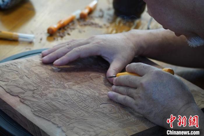 圖為徐晉林湊近木板，近距離制作雕版畫。　九美旦增 　攝