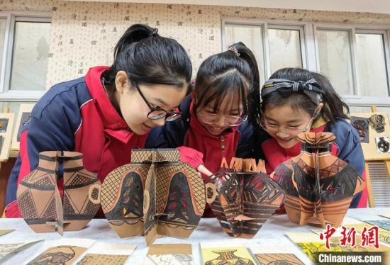 圖為學(xué)生用紙創(chuàng)作的立體彩陶?！⒂裉?攝