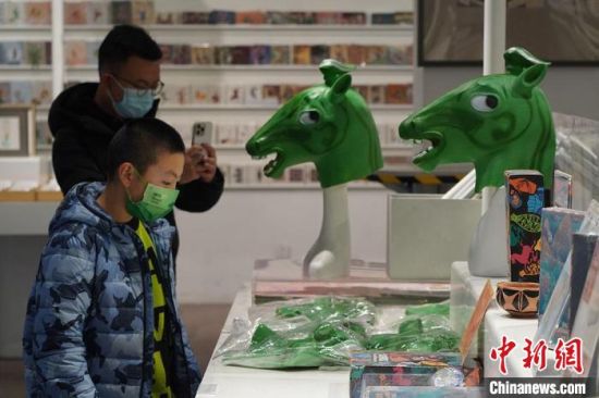 圖為“神馬來(lái)了”銅奔馬頭套吸引參觀(guān)者駐足。　九美旦增 攝