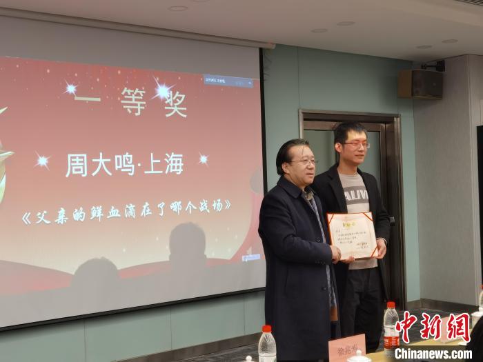 圖為作家、西北師范大學(xué)新聞與傳媒學(xué)院院長徐兆壽頒發(fā)一等獎證書，代領(lǐng)獎?wù)呱吓_領(lǐng)獎?！钅?攝