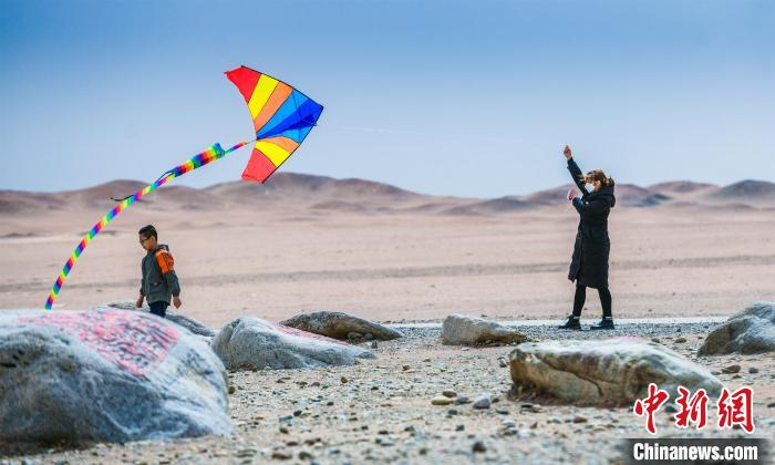 圖為市民正在陽關(guān)景區(qū)放風(fēng)箏。　王斌銀 攝