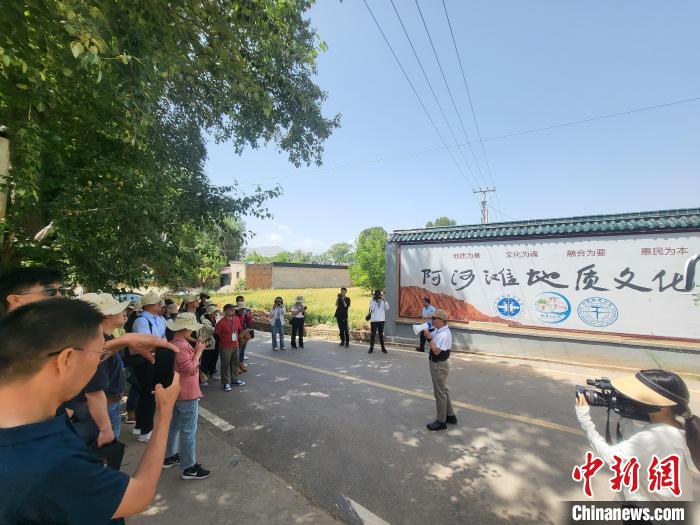 圖為中國地質(zhì)大學(xué)(北京)教授張緒教介紹村落情況?！『衍?攝