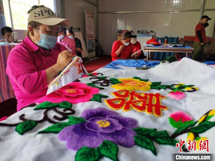 圖為婦女制作青繡?！?zhí)砀?攝