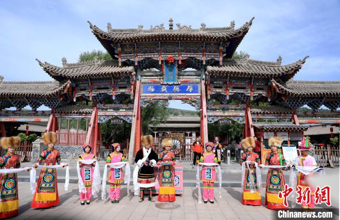 圖為身穿土族服飾的工作人員迎接訪客?！⊙Φ?攝