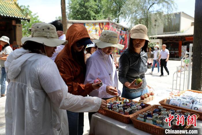 圖為民眾挑選手工藝產(chǎn)品?！⊙Φ?攝