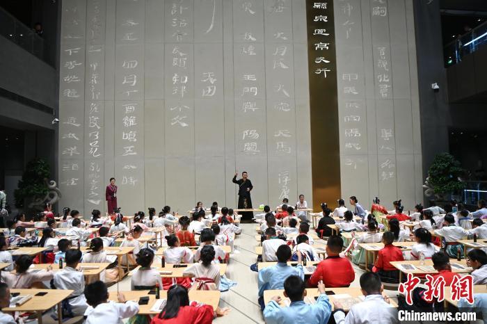 圖為9月7日，甘肅簡牘博物館開館儀式在蘭州舉行，小朋友們學(xué)習(xí)書寫簡牘中的文字?！≈行律缬浾?九美旦增 攝