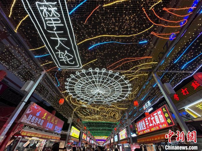 圖為明清街夜市燈光點(diǎn)亮具有武威文化元素的“摩天輪”彩燈?！〈魑牟?攝</p><p>