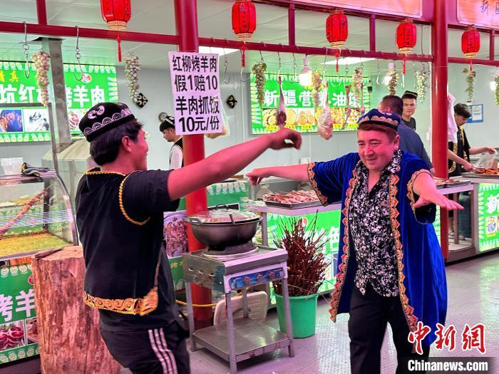 圖為餐飲經(jīng)營者在“西涼不夜城”跳起舞蹈引客?！〈魑牟?攝</p><p>