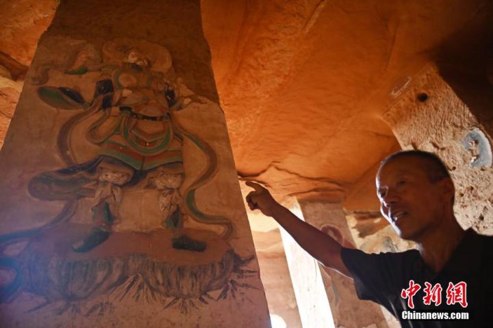 7月15日，甘肅省平?jīng)鍪袥艽h百里石窟長廊羅漢洞石窟內(nèi)，該窟文保員郭建平介紹窟內(nèi)石刻彩繪壁畫。郭建平家中三代人曾自發(fā)保護羅漢洞石窟。羅漢洞石窟遺存40余個窟龕，以北魏至清代風格為主。中新社記者 李亞龍 攝</p>
<p>