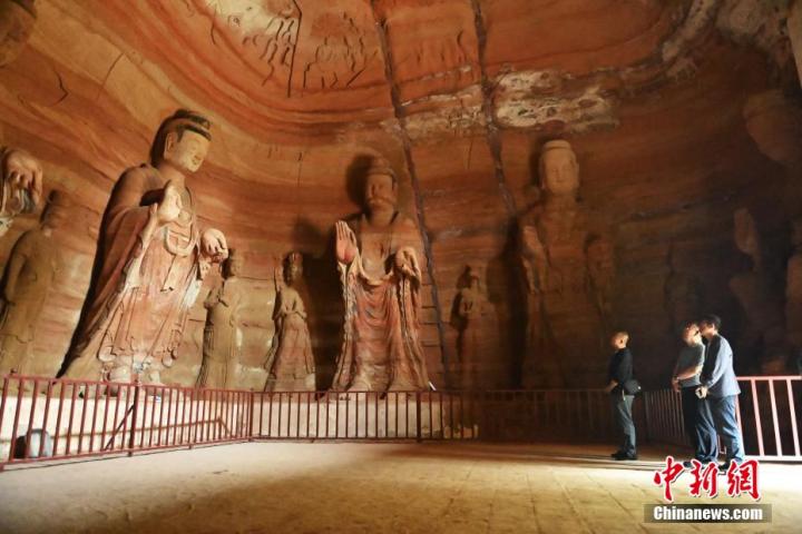 7月15日，游人參觀甘肅省平?jīng)鍪袥艽h百里石窟長廊中的南石窟寺1號窟。百里石窟長廊位于涇川縣境內(nèi)，由512個石窟、5眼窟中石井組成，現(xiàn)存王母宮石窟、鳳凰山石窟、南石窟寺、丈八寺石窟、羅漢洞石窟、太山寺石窟等規(guī)模較大的石窟群，還有數(shù)量眾多的小石窟群。南石窟寺開鑿于北魏永平三年，其中1號窟屬于大型七佛窟，七佛高達6米。中新社記者 李亞龍 攝