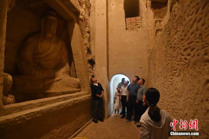 7月15日，游人參觀甘肅省平?jīng)鍪袥艽h百里石窟長廊中的王母宮石窟。百里石窟長廊位于涇川縣境內(nèi)，由512個石窟、5眼窟中石井組成，現(xiàn)存王母宮石窟、鳳凰山石窟、南石窟寺、丈八寺石窟、羅漢洞石窟、太山寺石窟等規(guī)模較大的石窟群，還有數(shù)量眾多的小石窟群。王母宮石窟又名千佛洞，該窟設(shè)計宏大，造像生動，窟內(nèi)擁有造像數(shù)百尊，是較為珍貴的佛教文化歷史遺存。中新社記者 李亞龍 攝</p>
<p>