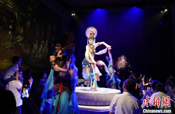 《樂(lè)動(dòng)敦煌》是全球首部洞窟式沉浸體驗(yàn)劇，利用真人與數(shù)字影像虛實(shí)交換實(shí)現(xiàn)沉浸式體驗(yàn)。圖為2023年8月28日晚，《樂(lè)動(dòng)敦煌》演出。(資料圖)中新社記者 毛建軍 攝